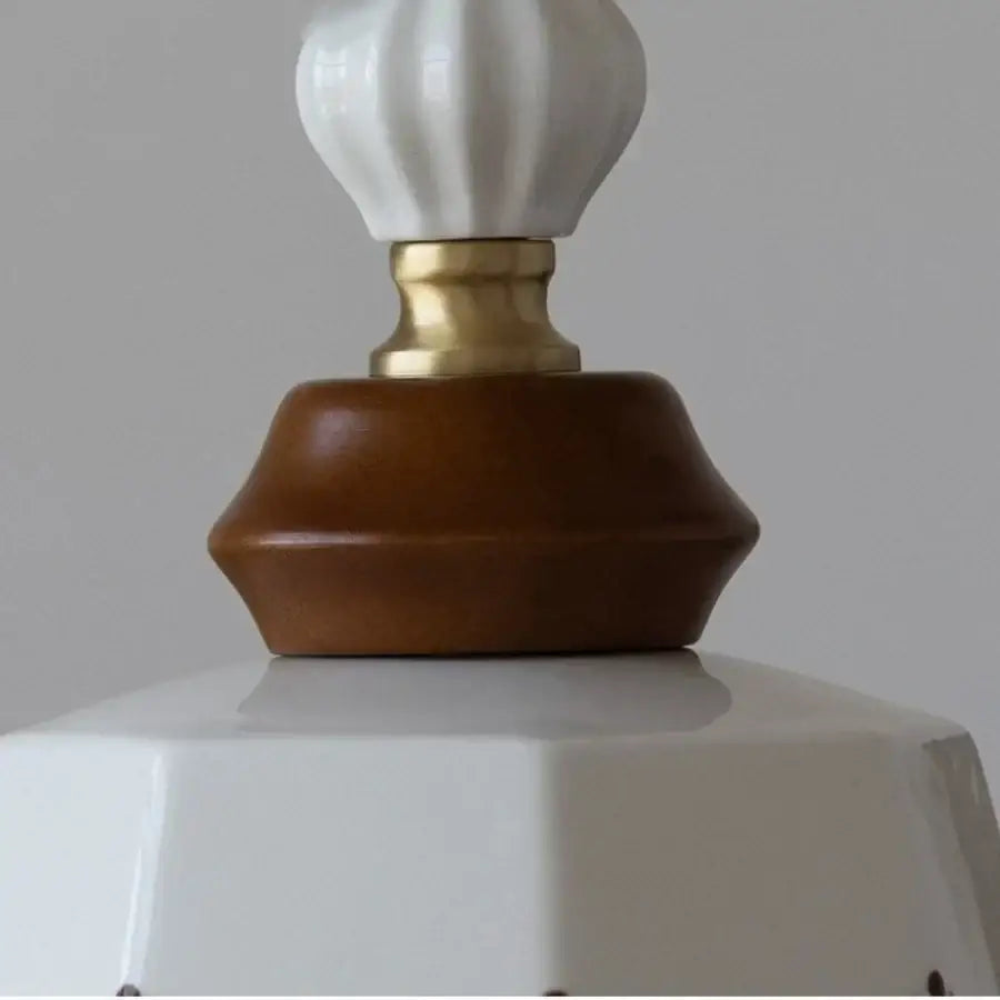 Vintage pendant lights featuring a white ceramic lampshade with a gold-toned metal base and brown wood ceramic accent