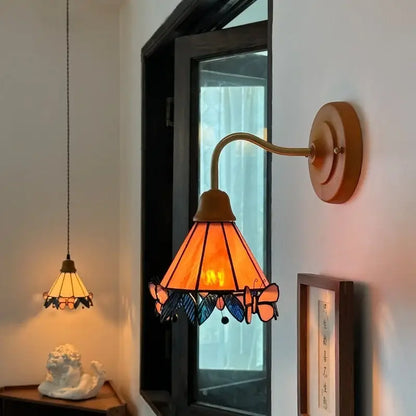 Warm amber wall light with copper arm and wooden mount featuring decorbites butterfly glass design for bedroom decor