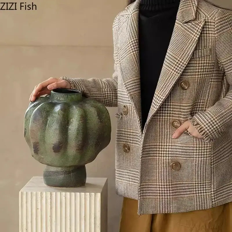 A rustic green vintage ceramic vase with textured pumpkin shape displayed on white pedestal for living room decorbites