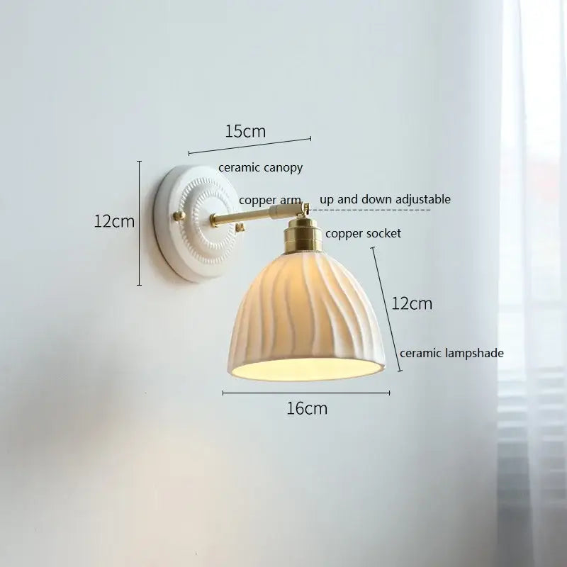 Cream-colored decorbites ceramic wall lamp with ribbed fluted glass shade and copper accents for bedroom decor