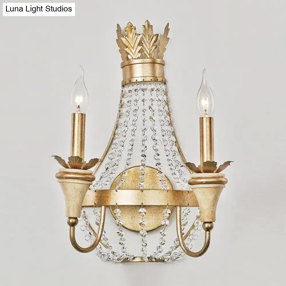 Gold-finished crown-themed wall light with champagne finish and clear crystal accents for elegant living room decor