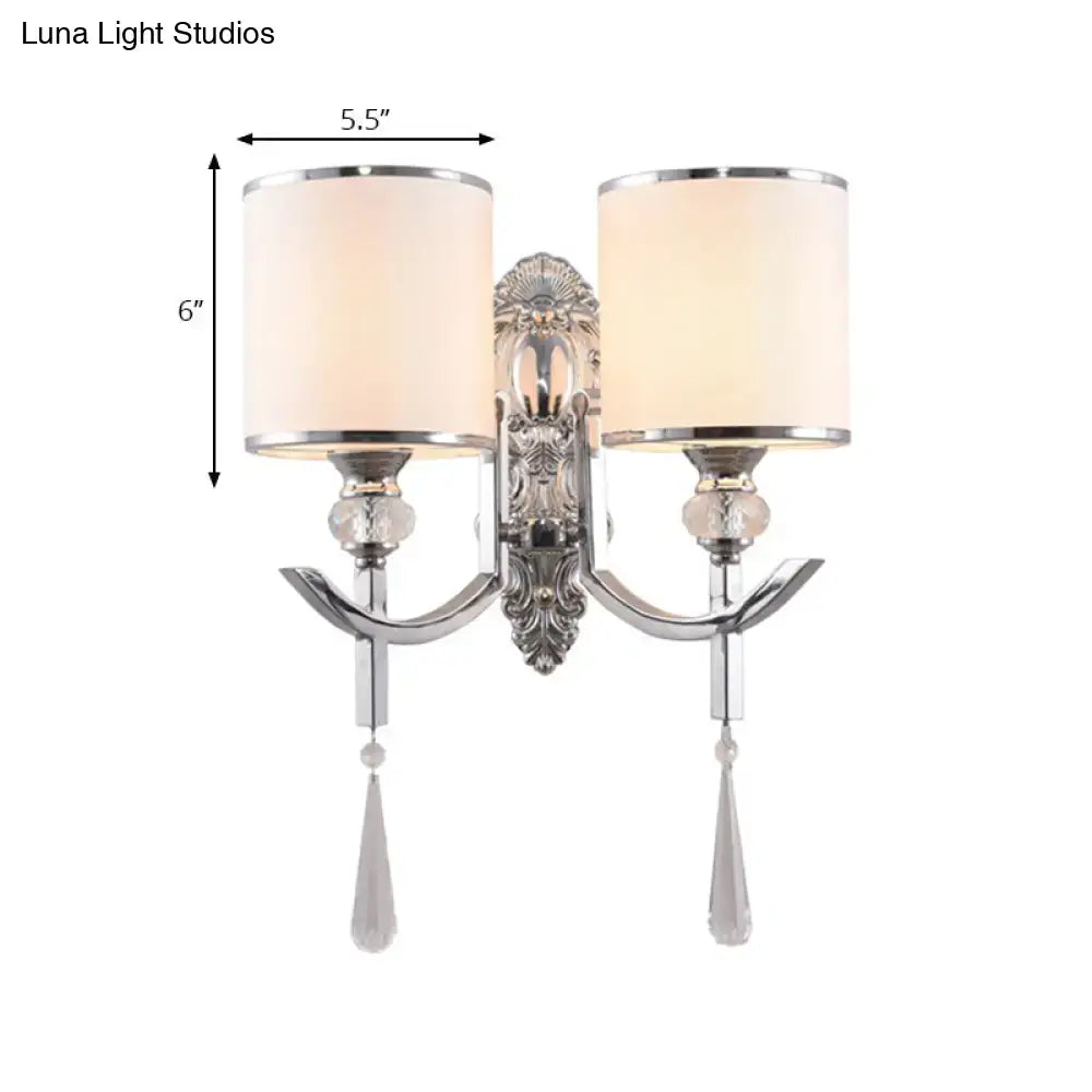 Vintage chrome wall sconce with carved backplate featuring silver ornate two-light design and cream fabric shades with crystal droplets