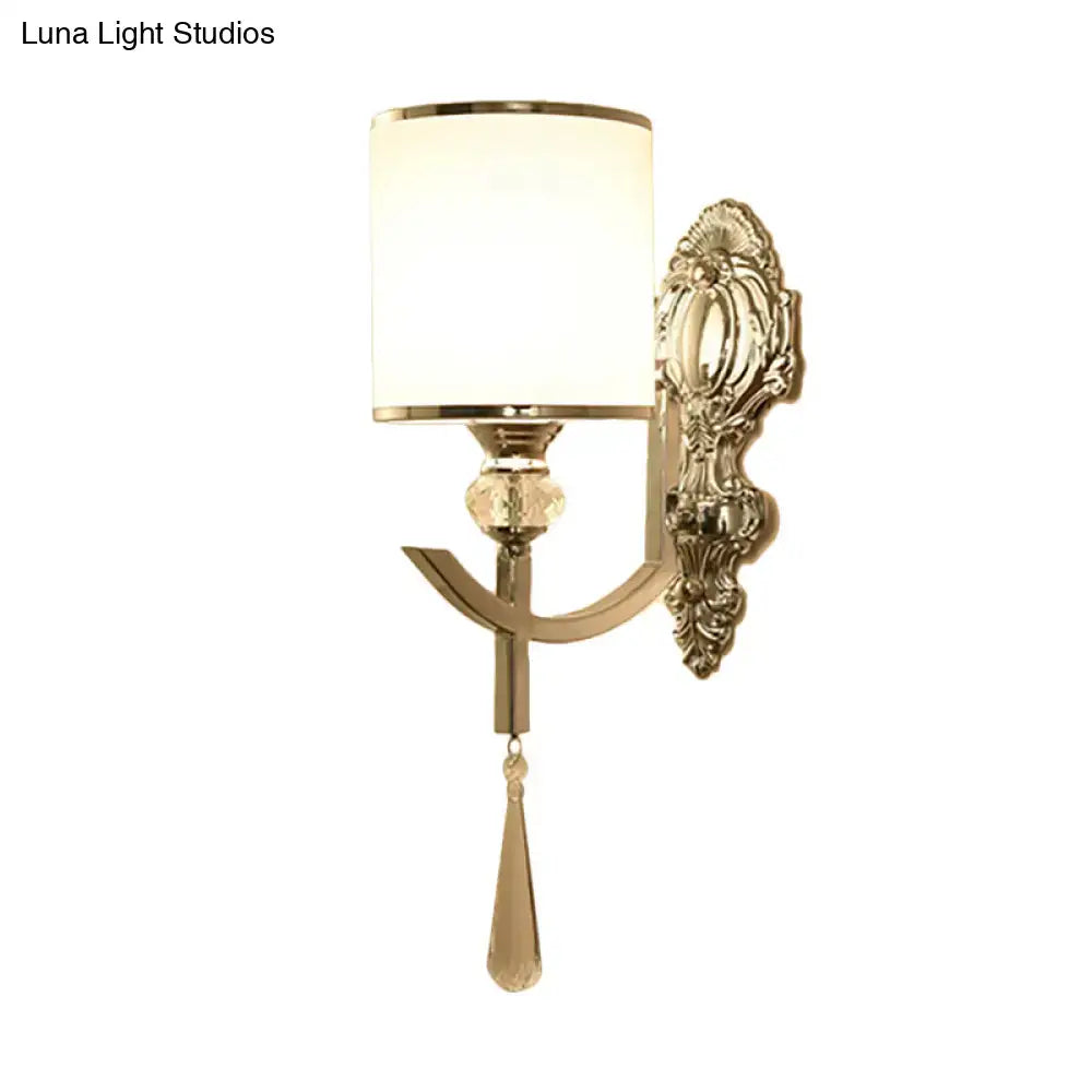 Gold-toned vintage wall sconce with carved backplate, frosted glass shade, and crystal teardrop accent for led and incandescent lighting