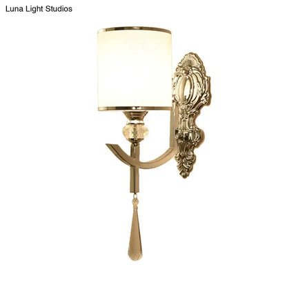 Gold-toned vintage wall sconce with carved backplate, frosted glass shade, and crystal teardrop accent for led and incandescent lighting