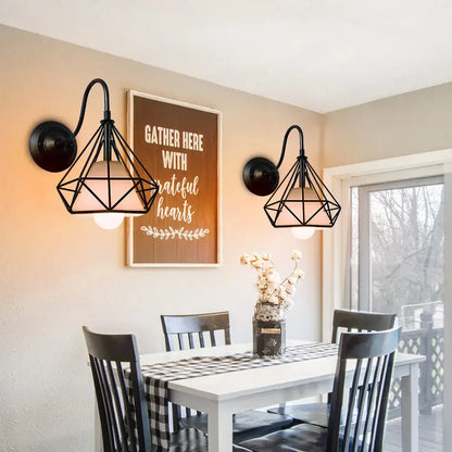 Black geometric wireframe wall sconce with warm bulbs featuring decorbites iron cage and iron cage guard design
