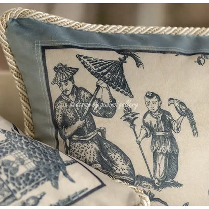 Cream-colored vintage delft blue toile cushion cover with navy blue figures and rope trim for living room decorbites decor