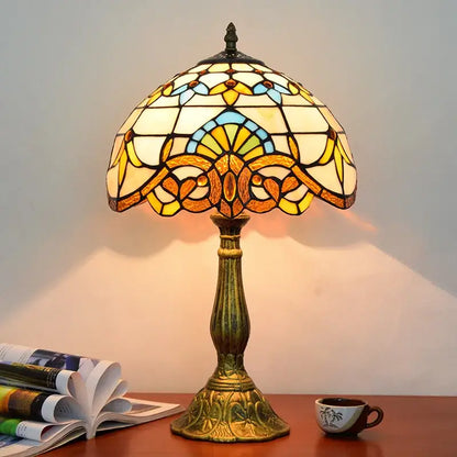 Vintage dragonfly tiffany stained glass table lamp with intricate amber yellow and blue floral patterns on a brass base