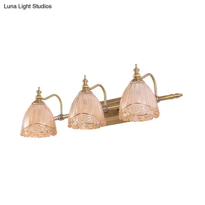 A three-light vintage floral amber glass wall sconce with brass arms and pink-tinted etched glass shades for bedroom use