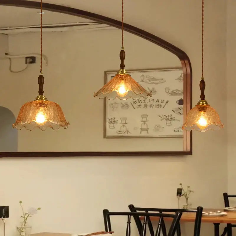 Three amber cracked glass pendant lights with brass accents and wooden finials for vintage floral decorbites cracked glass decor