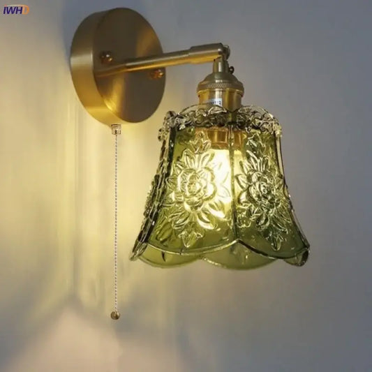 Vintage floral green glass led wall lights featuring a brass-finished arm and embossed olive-green glass shade sconce