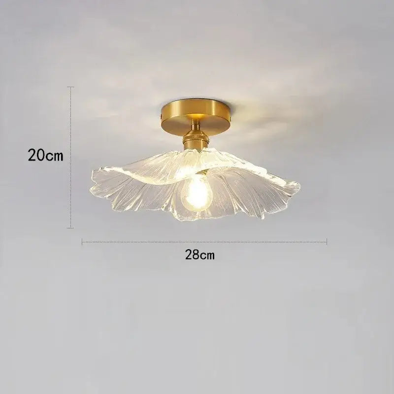 A delicate translucent glass pendant light with golden brass base and exposed bulb from vintage flower trio