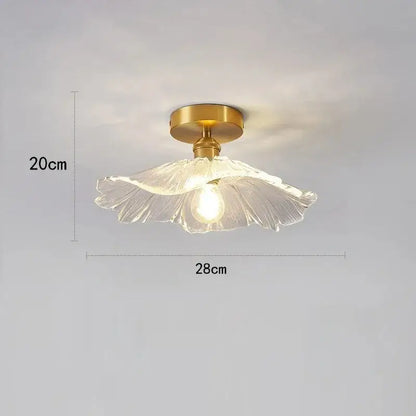 A delicate translucent glass pendant light with golden brass base and exposed bulb from vintage flower trio