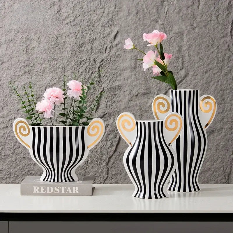 Three black and white striped ceramic vases with gold spiral handles holding pink flowers vintage geometric fringe decorbites ceramic vase