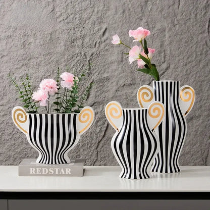 Three black and white striped ceramic vases with gold spiral handles holding pink flowers vintage geometric fringe decorbites ceramic vase