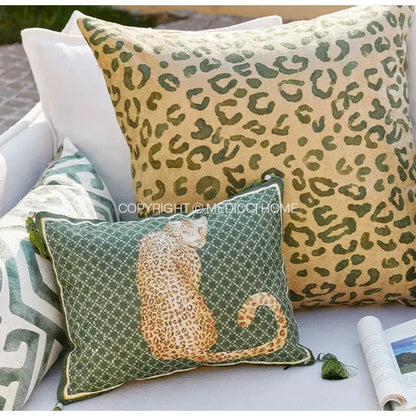 Green bolster pillow case with embroidered tan and beige cheetah on dark green geometric diamond pattern background