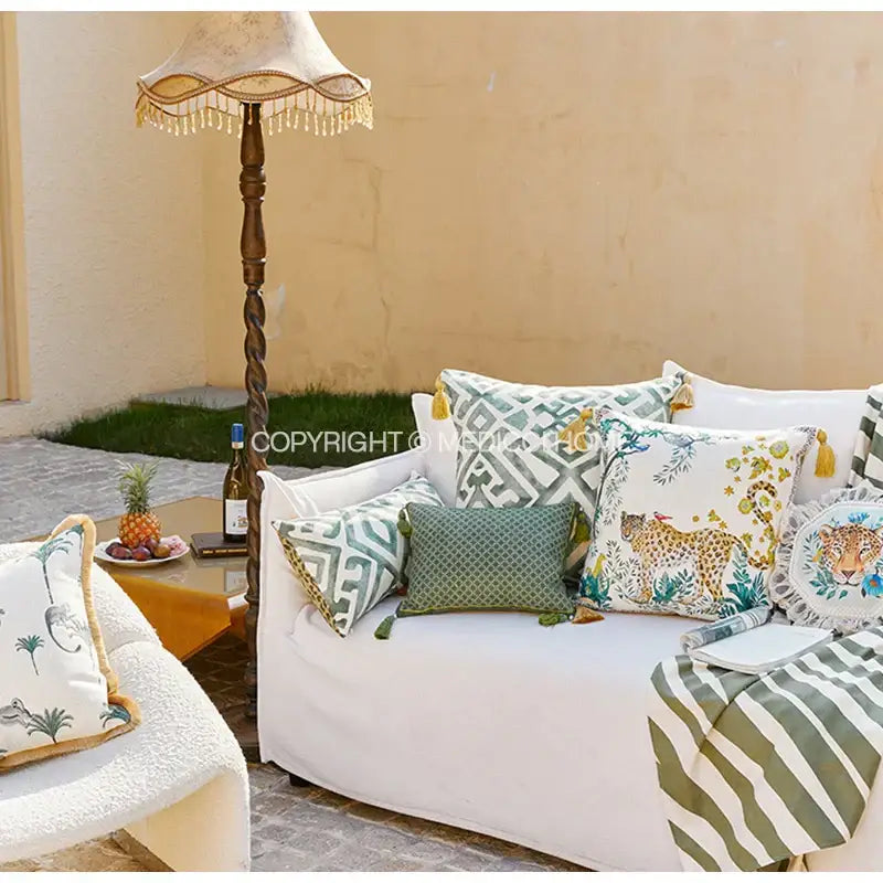 White sofa with vintage geometric and leopard bolster pillow case in green beige and gold tones for bedroom decor