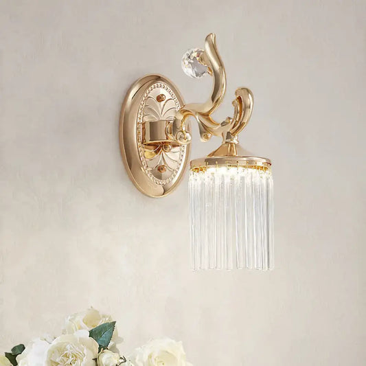Vintage gold wall mounted light with clear pipe prisms and ornate curved arms for elegant bedroom lighting