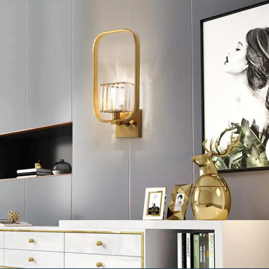 Gold finish vintage metal wall sconce with rectangular crystal shade and vertical accents for bedroom lighting