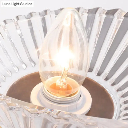 Vintage gold finish shell wall lamp with frosted glass shade and glowing clear candle-style bulb for bedroom use