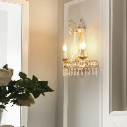 Vintage gold metallic exposed wall lamp wall sconce with two candle-style bulbs and crystal droplets