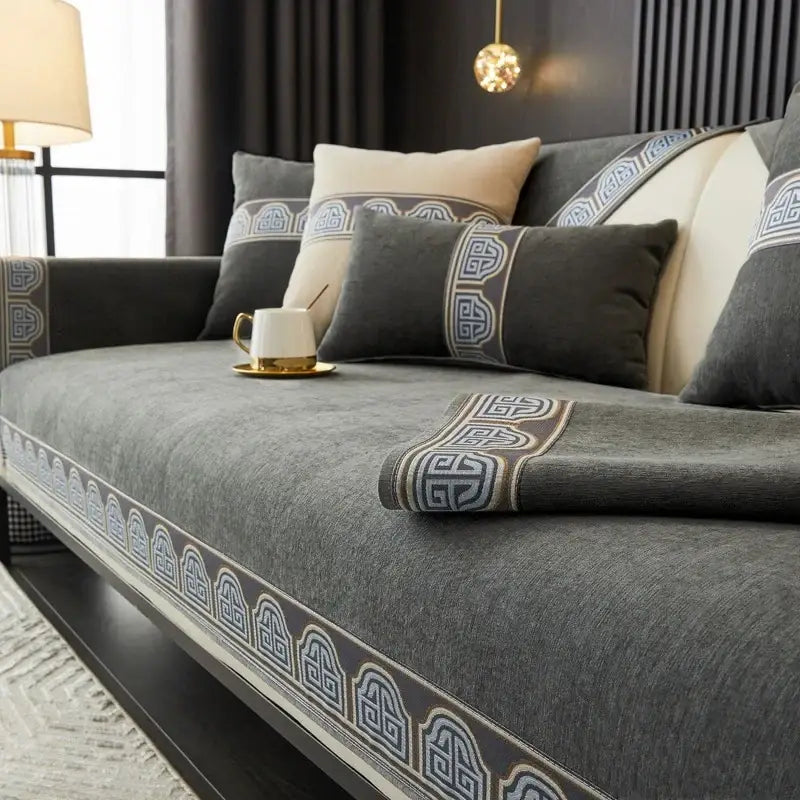 Vintage gray chenille sofa cover with intricate blue and gold geometric embroidery along the edges for living room