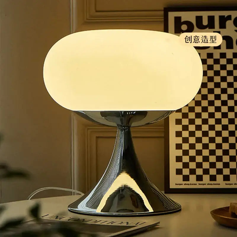 A vintage green and cream glass table lamp with a sleek frosted shade and polished chrome base for bedroom decor