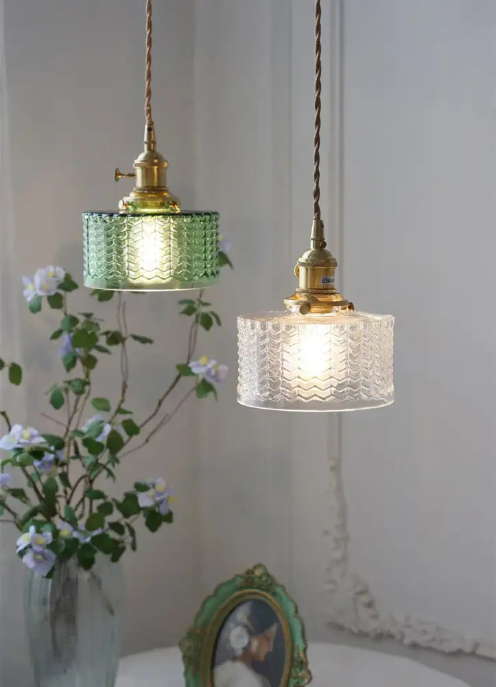 Two vintage glass shade chandelier pendant lights with green and clear textured glass shades and brass fixtures hanging from cords