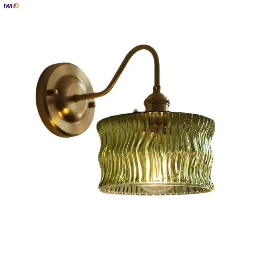 Vintage wall light with brass arm and copper knob switch featuring an olive green glass shade with vertical ridges