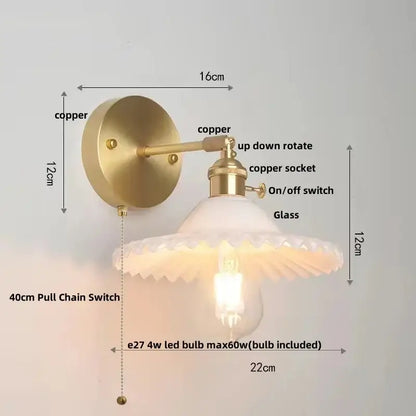 Vintage green glass wall light with brass sconce and pull chain switch featuring frosted glass shade and exposed bulb