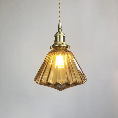 A warm amber glass pendant light with brass pumpkin led fixture and twisted cord for vintage decorbites style