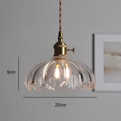 Clear ribbed glass pendant light with brass fixture and twisted cord thoughtfully styled for dining room use