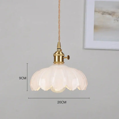 Delicate white glass pendant light with brass fixture and twisted cord thoughtfully styled for dining room use
