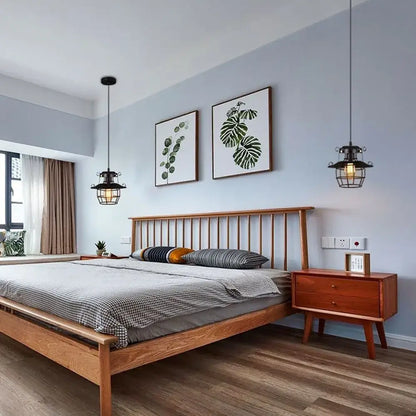 Lightweight wooden bed with slatted headboard and matching nightstand under vintage industrial black metal cord pendant light