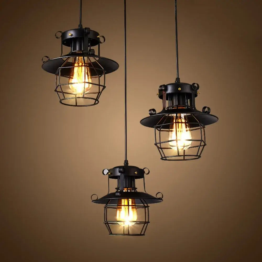 Three vintage industrial black metal pendant lights with cage frames and exposed filament bulbs for kitchen use
