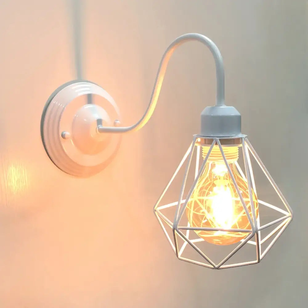 White metal wall lamp with curved arm and geometric cage housing bulb for decorbites industrial cage wall decor