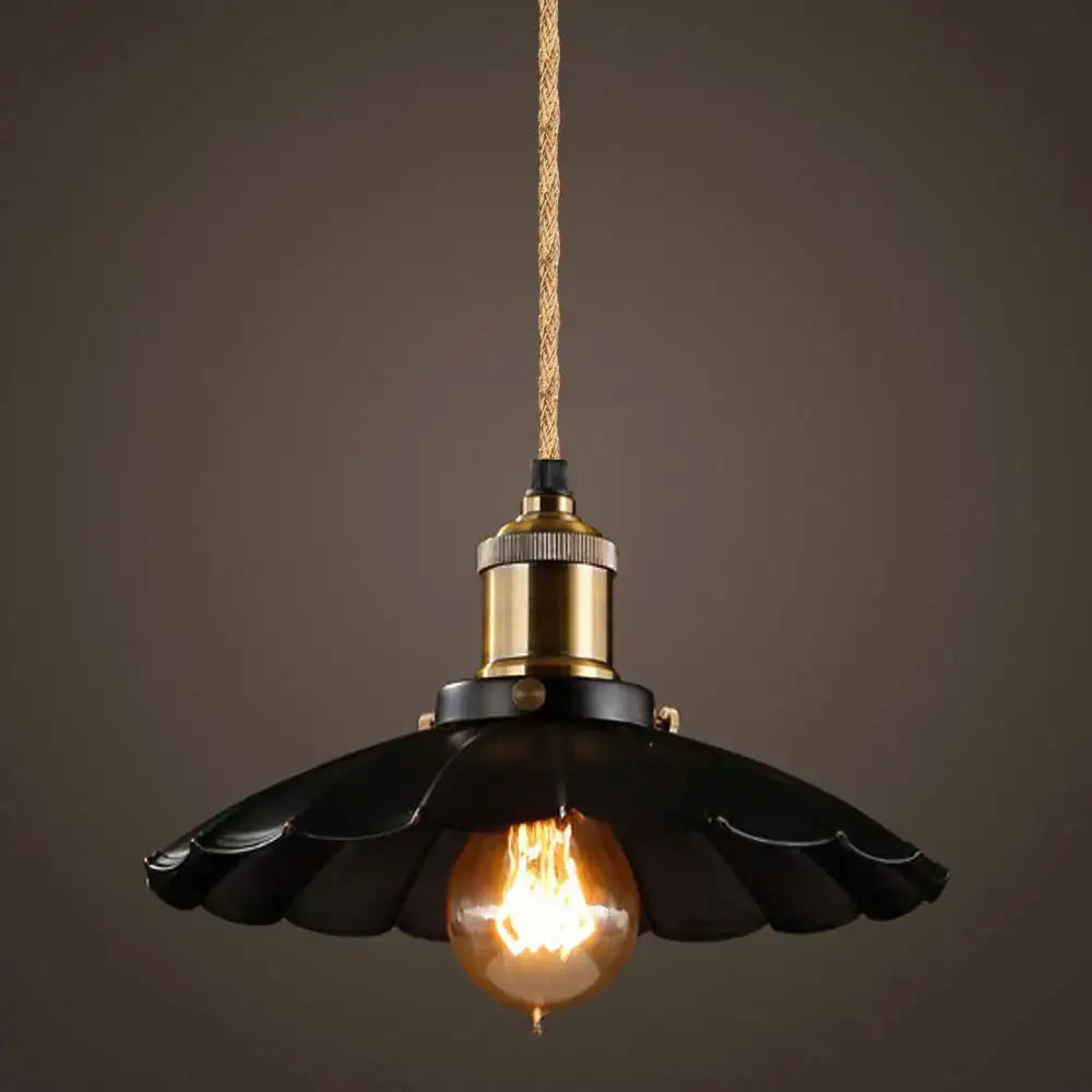 Black scalloped metal pendant light with brass socket and exposed filament bulb featuring woven textile wire and hemp rope