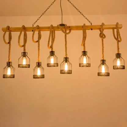 Rustic wooden beam island lighting fixture with six glass bottle shades suspended by rope and metal chains in black