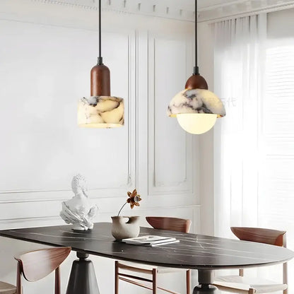 Two warm-toned vintage marbled glass ball led pendant lights with dark brown tops hang over a dining table decorbites glass ball
