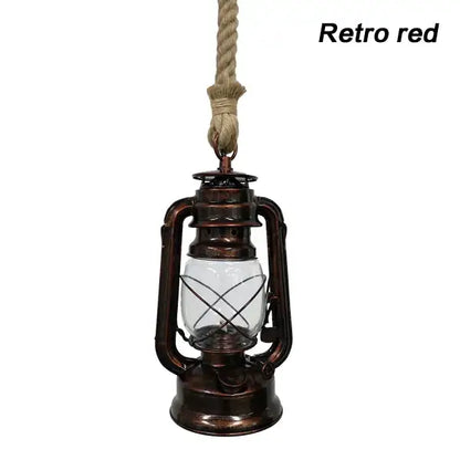 Vintage mixed metal cage pendant light with a red hanging lantern, copper metal construction, and clear glass globe for decorative presence