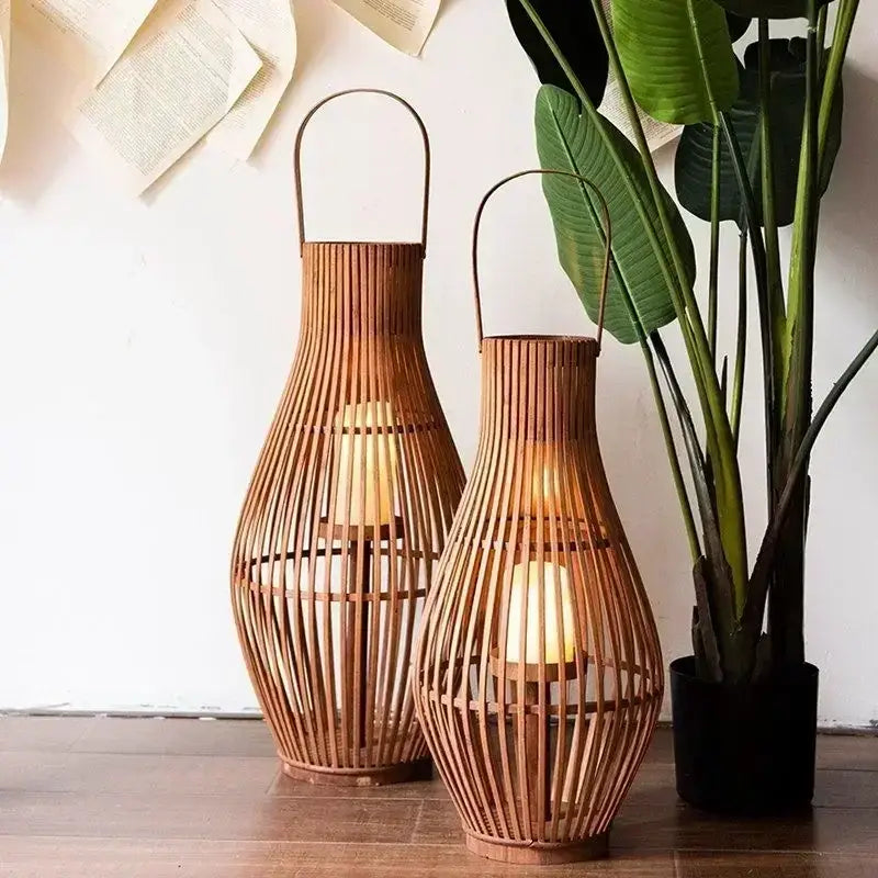 Two elegant vintage natural bamboo lantern candle holders with warm glowing candles for living room floor decor