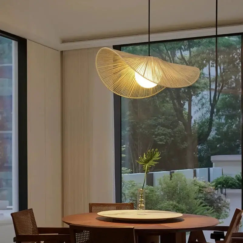 A vintage off-white cotton rope hat pendant light with woven bamboo design hangs warm above the dining table