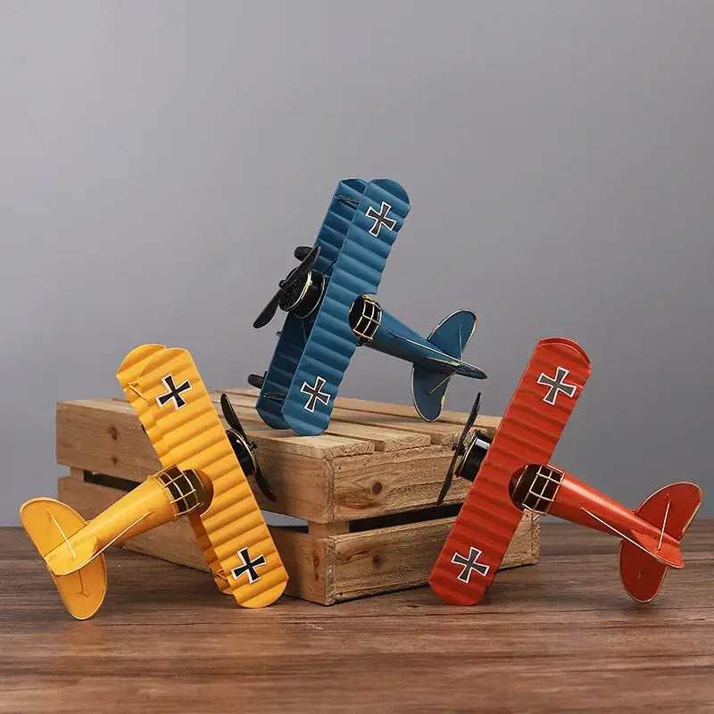 Three vintage-style yellow, blue, and red iron airplane figurines with black cross accents for bedroom decorbites decor