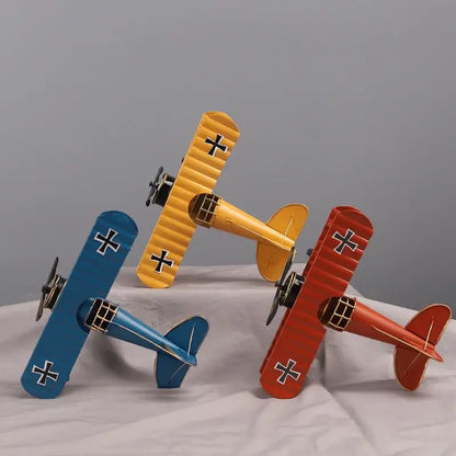 Three colorful iron airplane figurines in blue yellow and red with black cross accents for vintage bedroom decorbites decor