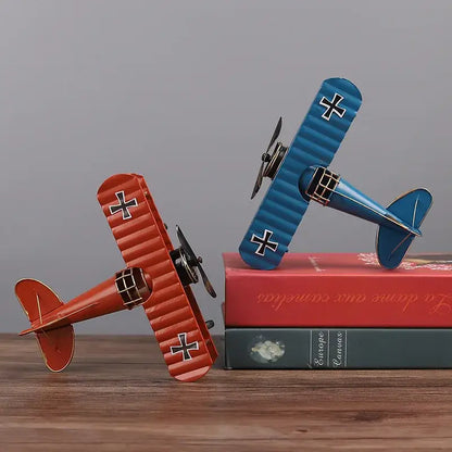 Two vintage-style red and blue iron airplane figurines with black cross accents perfect for bedroom decorbites decor