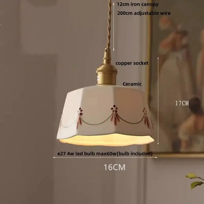 Cream-colored ceramic pendant light fixture with brown floral embroidery and brass copper socket for dining room use