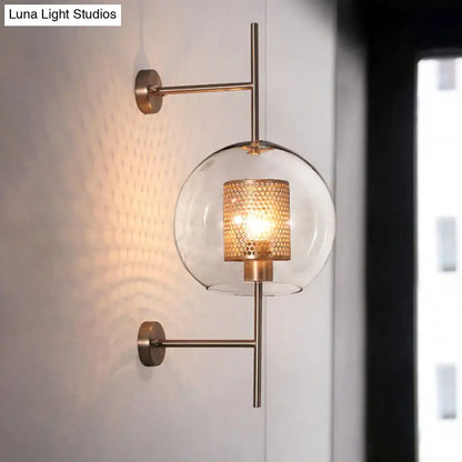 A vintage silver and gold modern clear glass sconce light with brass and amber honeycomb-patterned shade for bedroom wall