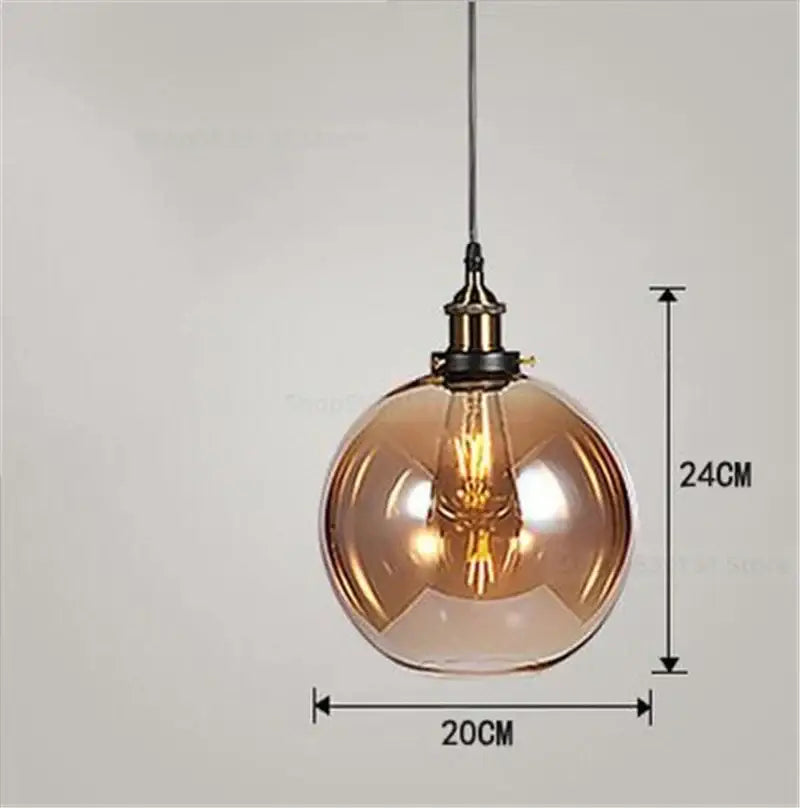 A warm-toned vintage smoked glass ball pendant light with brass fixture and exposed filament bulb decorbites glass ball