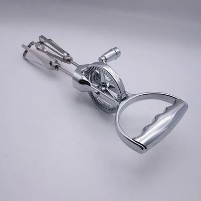 Vintage stainless steel egg beater with shiny chrome finish curved handle and dual beater balloon whisk attachments