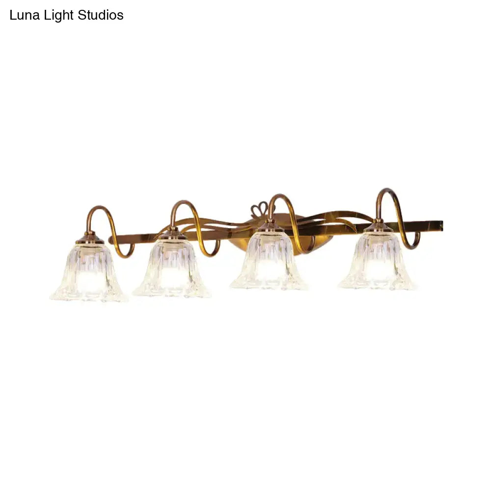 Vintage style wall light with brass finish and four clear bell-shaped glass shades for bathroom vanity lighting
