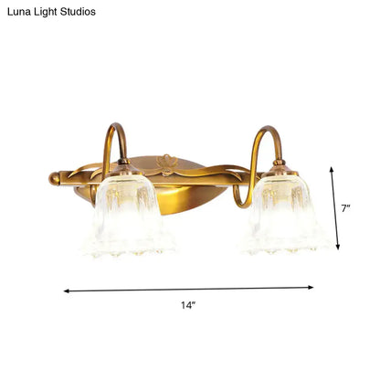 Vintage style antique brass two-light wall light with clear textured glass shades for bathroom vanity use